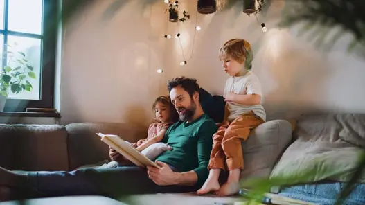 Eine Familie sitzt gemütlich auf dem Sofa
