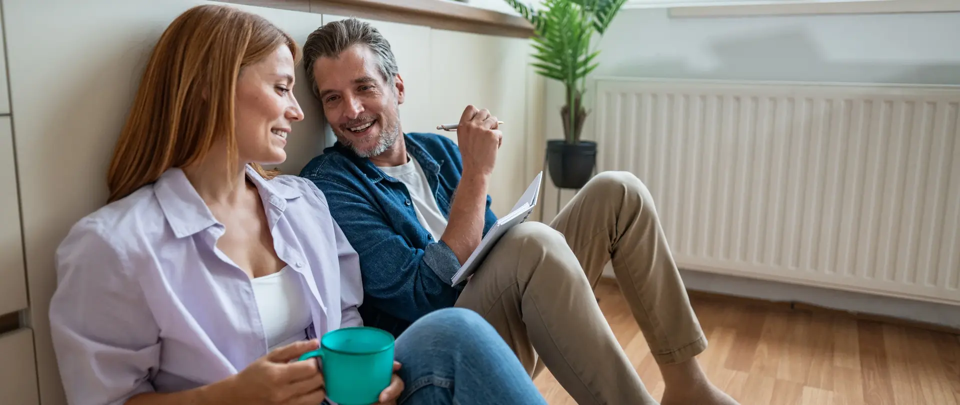 Mann und Frau im Gespräch vor einer Heizung