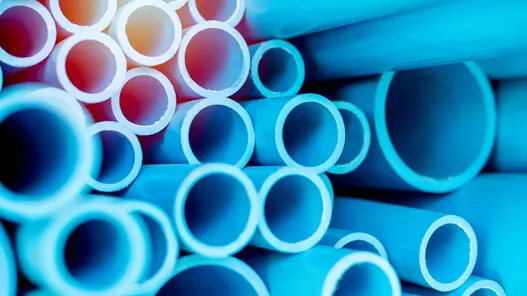 Rohre von Gas- und Wasserleitungen in blauer Farbe sind übereinandergestapelt.