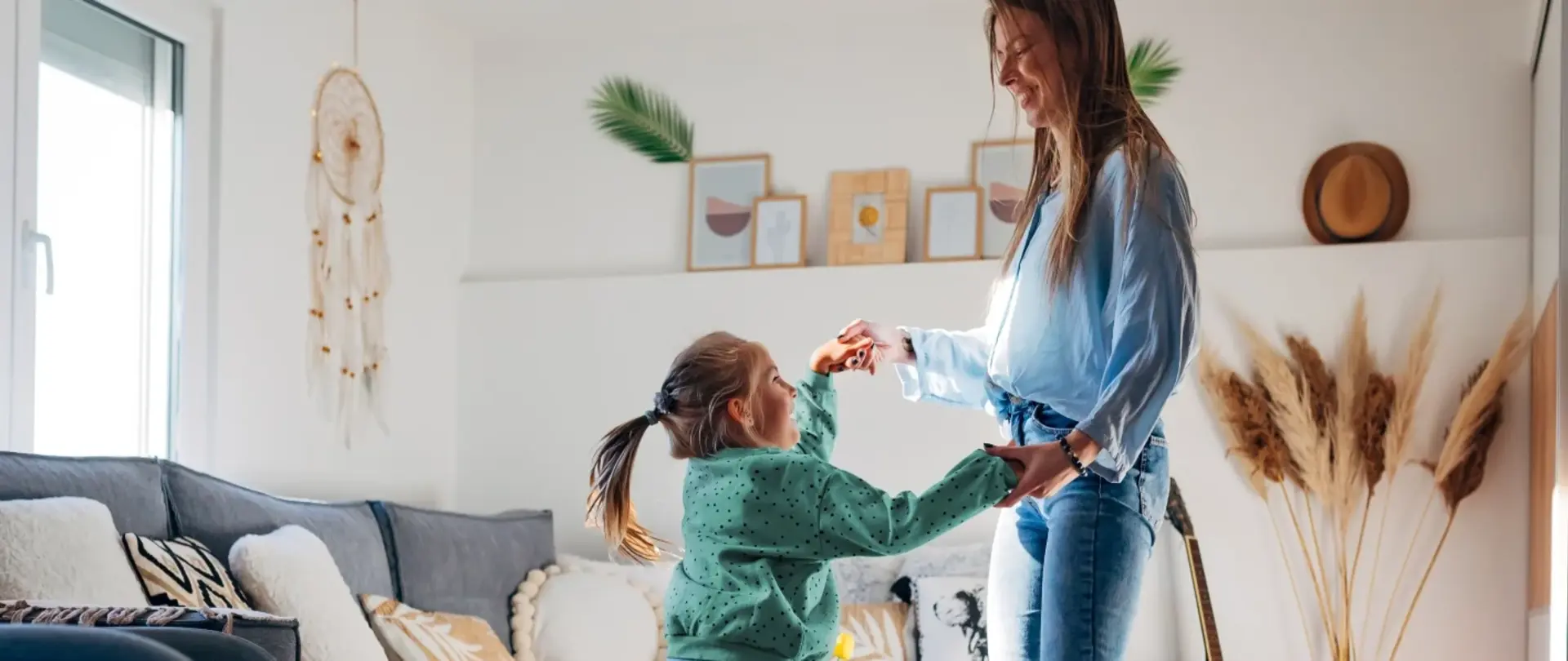 Eine Mutter tanzt mit ihrer Tochter in einem schön eingerichteten Wohnzimmer