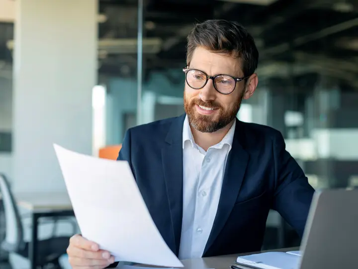 Transformationsplan der energetischen Optimierung Ein Mann hält den Transformationsplan von Westfalen Weser in der Hand, der ein wirtschaftlich optimales Szenario aufbereitet.