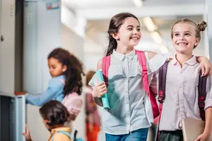 Kinder gehen fröhlich durch den Schulflur