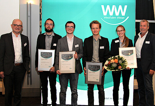 Gruppenbild mit sechs Personen stehend und Urkunde in der Hand von der ISFH Hameln 