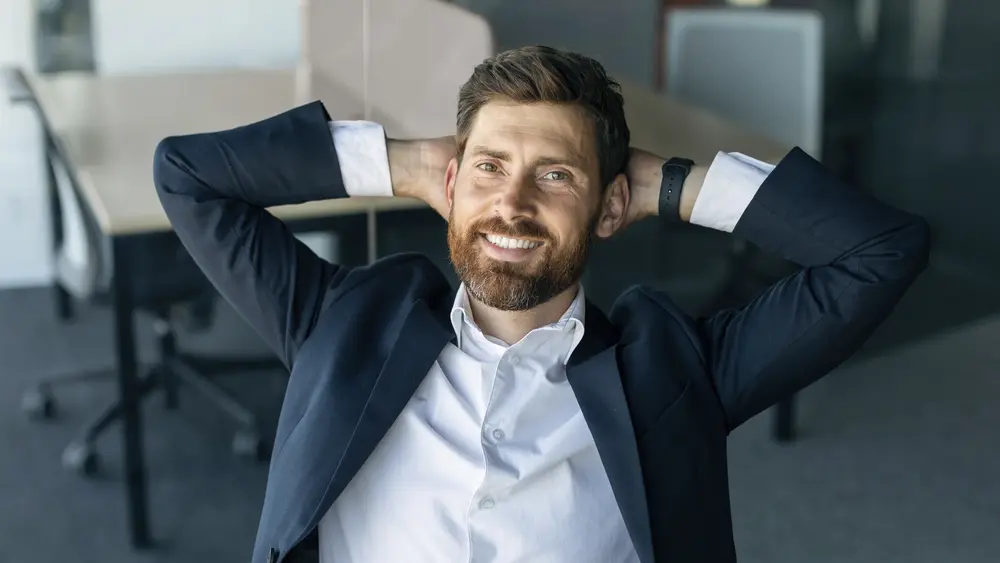 Business Mann sitzt im Stuhl mit verschränkten Armen