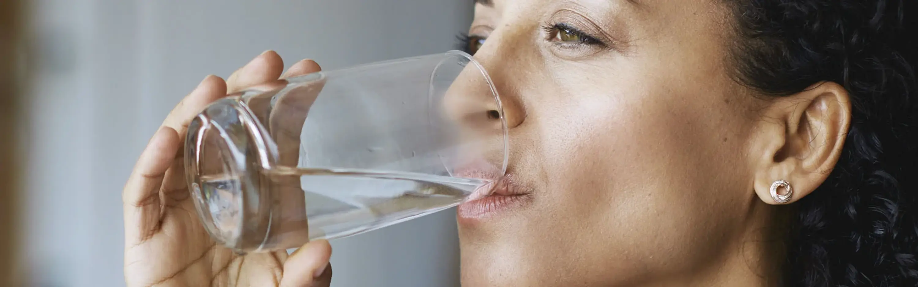Frau trinkt Wasser aus einem Glas