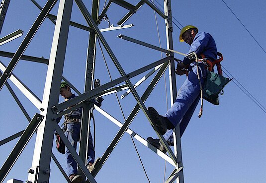 Mitarbeter klettern auf einem Mast