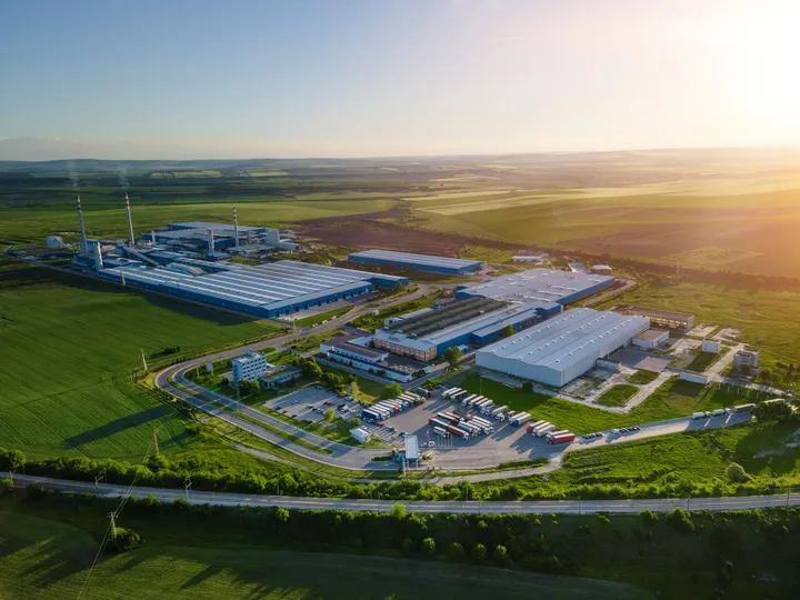 Ein großer Industriebetrieb mit Fabrikhallen wird zuverlässig von energietechnischen Anlagen versorgt.