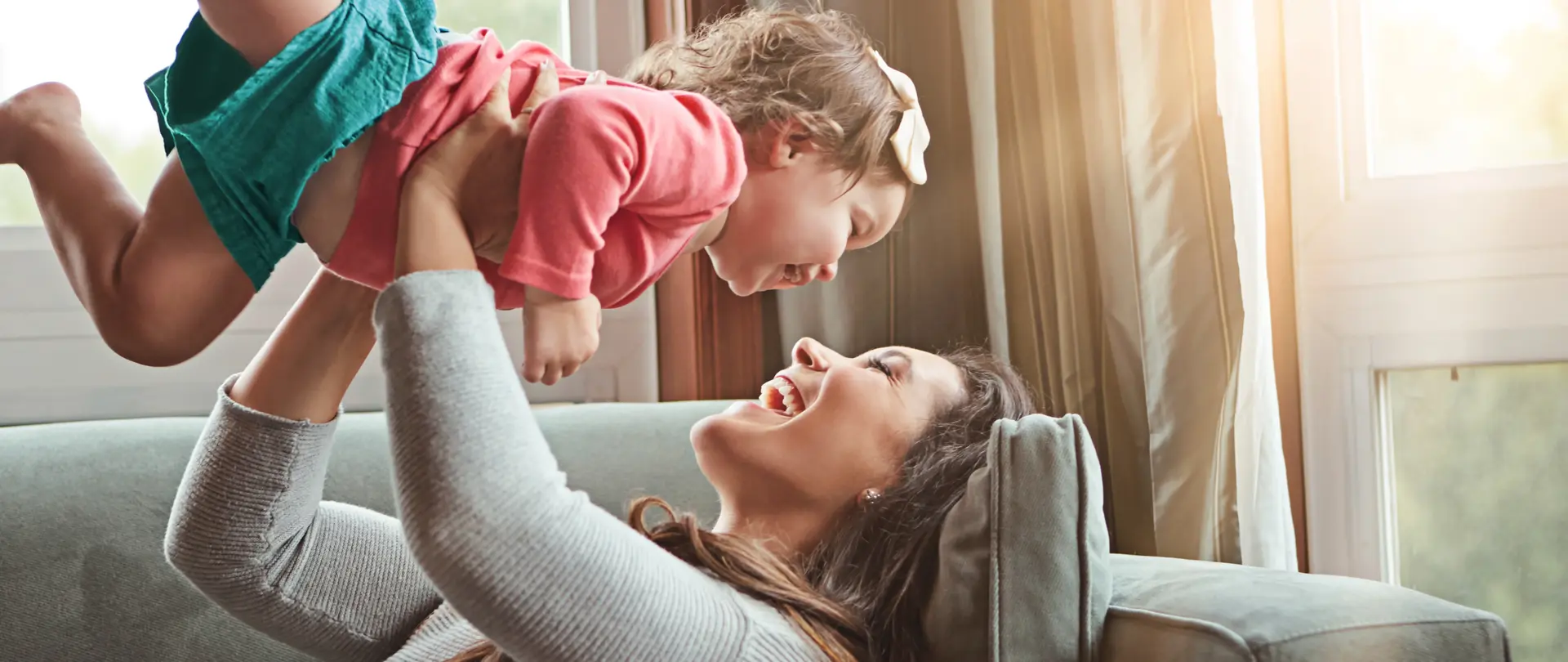 Mutter hebt Kind hoch.