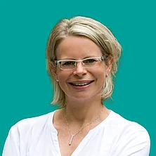 Auf dem Bild ist eine freundlich lächelnde Frau im weißen Shirt zu sehen