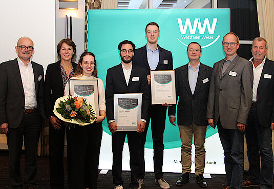 Gruppenbild mit acht Personen stehend und einer Urkunde in der Hand von der Technischen Hochschule OWL