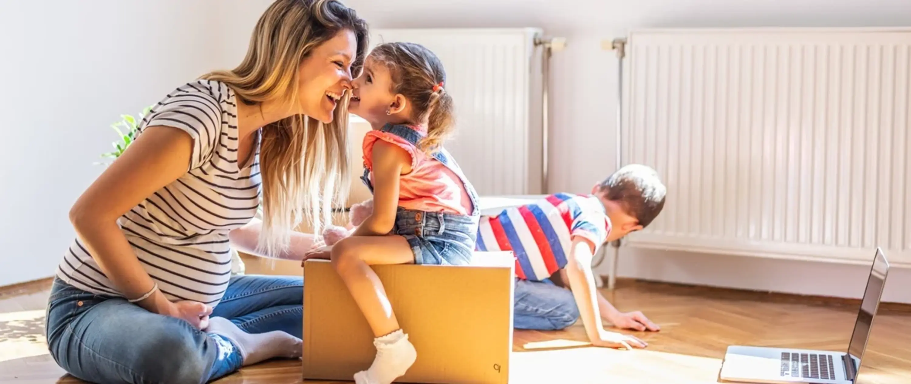 Mutter spielt mit ihren Kindern in einem Raum vor Heizkörpern