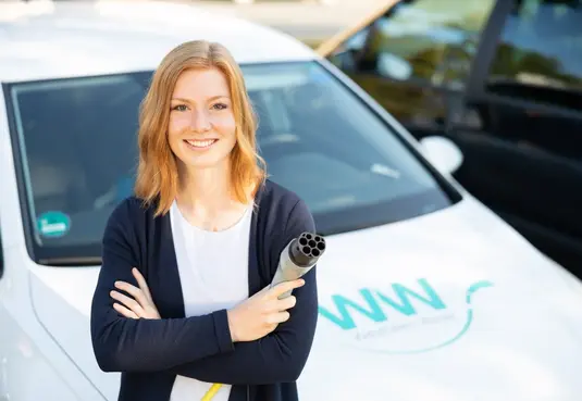 Mitarbeiterin von WW mit Elektroauto