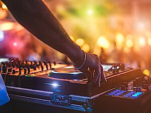 DJ Pult mit Turntables und verschwommenem Publikum