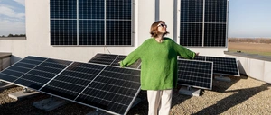 Eine Frau steht auf einem Dach mit Photovoltaik.