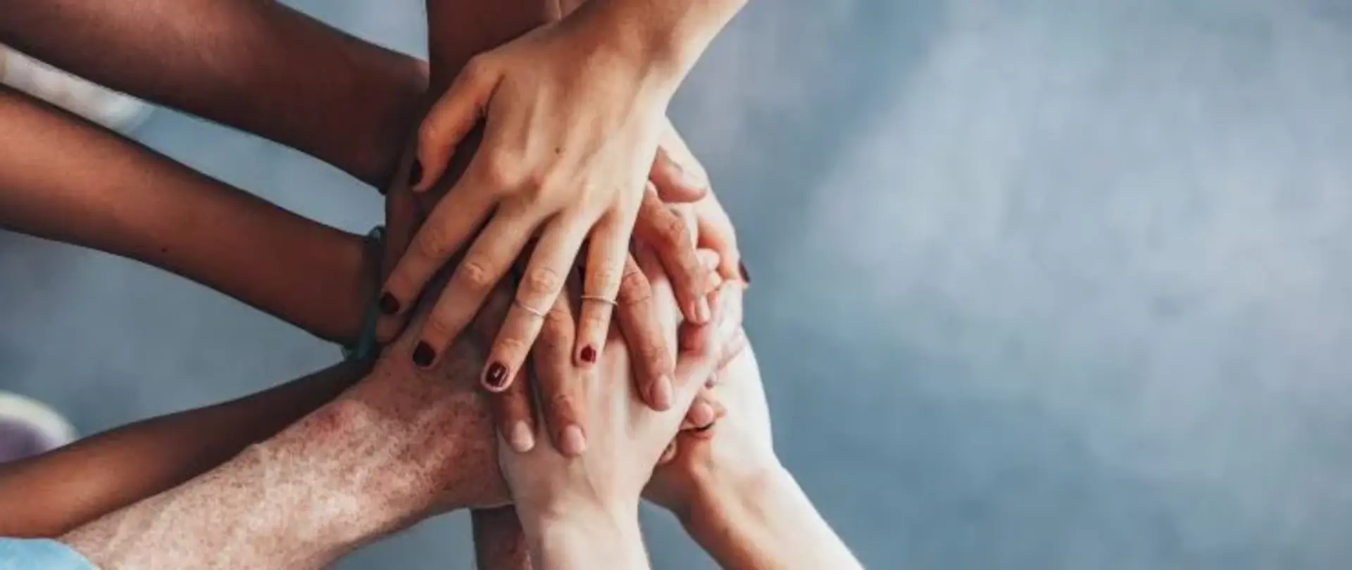 Viele Hände halten sich übereinander zusammen