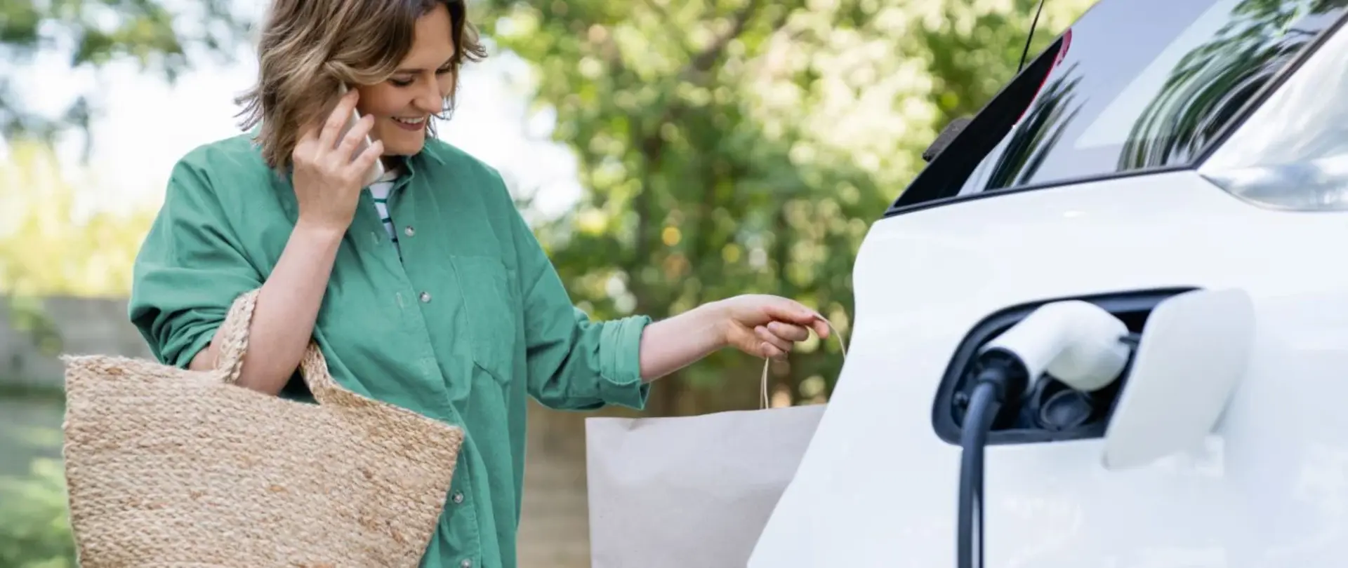 Eine Frau lädt ihr E-Auto während eines Einkaufs an einer Schnellladesäule
