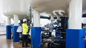 Monteur kontrolliert Leitungen in einem Wasserwerk.