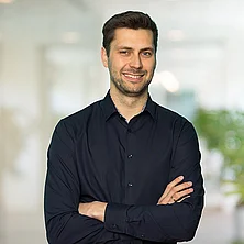 Porträtbild von Christian Debowicz vor unscharfem Bürohintergrund