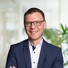 ndreas Stoller im Business-Outfit vor einem modernen Hintergrund, zuständig für E-Mobilitätslösungen.