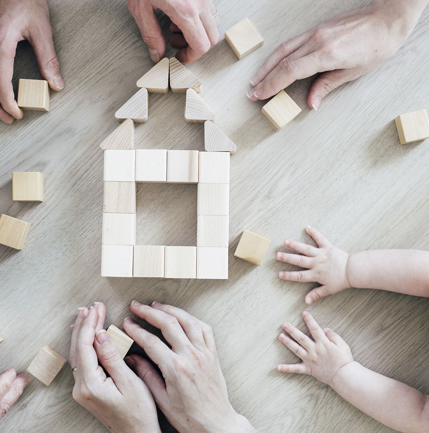 Familie baut ein Haus mit Bauklötzen