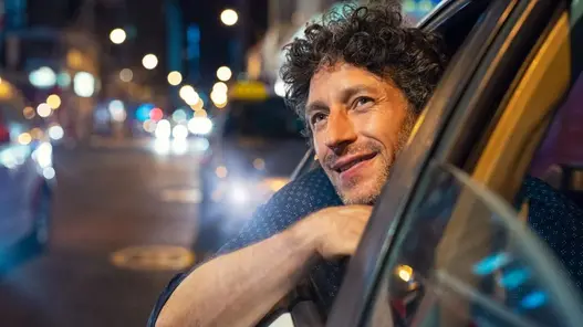 Ein Mann schaut sich aus dem Auto raus die Straßenbeleuchtung in der Innenstadt an
