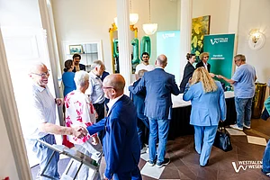 Westfalen Weser Klima.Sieger Preisverleihung: Die Besucher der Veranstaltung trage sich in die Teilnehmerliste ein. Es sind mehrere Menschen am Empfang zu sehen.