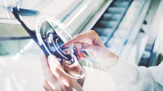 Eine Person nutzt ein Tablet mit eingeblendeten digitalen Interface-Elementen, die Datennutzung und Technologie symbolisieren.