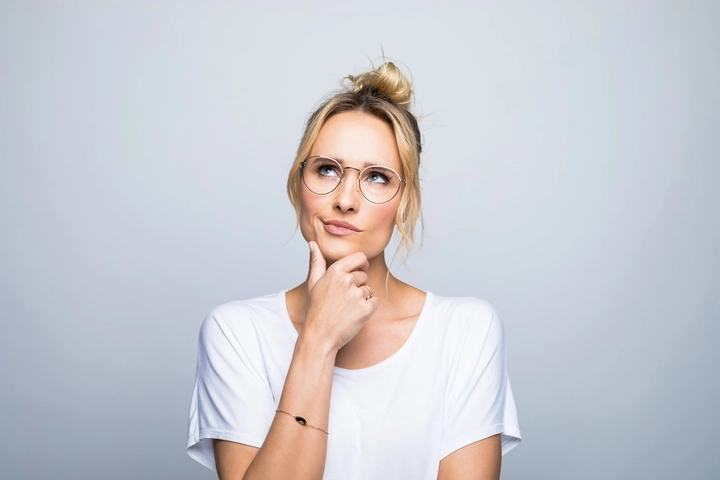 Frau mit weißem Shirt in Denkerpose