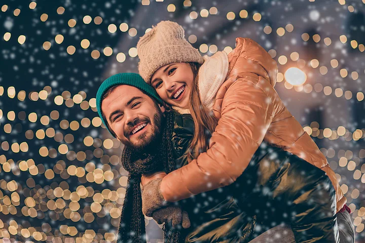 Der Titel der dritten Ausgabe des Kundenmagazins ENERGIEgeladen zeigt ein Pärchen in Winterkleidung, die Huckepack in einem weihnachtlichen Lichterschein stehen.