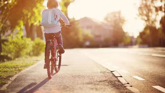 Kind auf dem Fahrrad auf dem Radweg