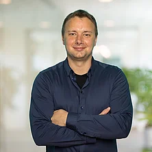 Porträtbild von Steve Flechsig vor unscharfem Bürohintergrund