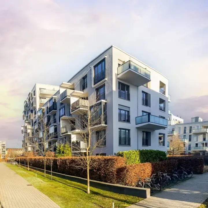 Eine Siedlung mit modernen Mehrfamilienhäusern. Ein Fußweg verläuft zwischen den Häusern