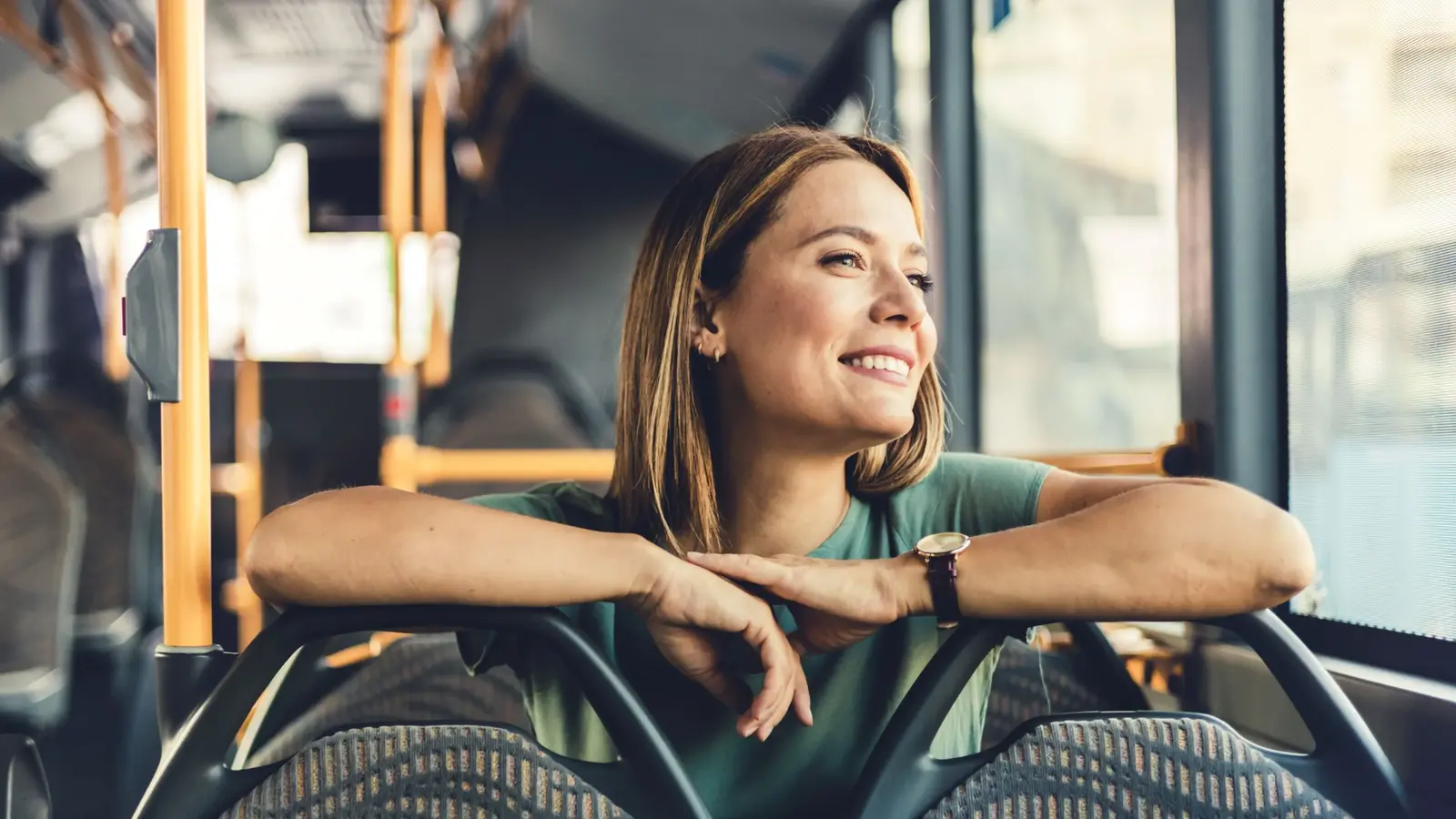 Eine Person sitzt entspannt im Innenraum eines Linienbusses.