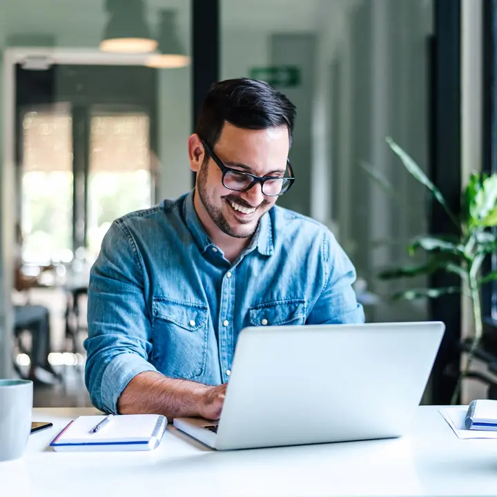 Eine Person arbeitet am Laptop in einem modernen Büro – für digitale Steuerung von Ladeinfrastruktur.
